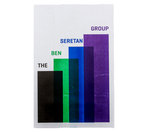 A printed poster with four bars of color reading THE BEN SERETAN GROUP