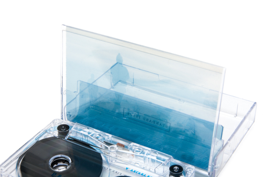 A tape cassette case with blue transparent paper stood up against the light