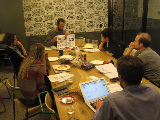 Six people sitting around a conference table looking at image ideas for a booklet project